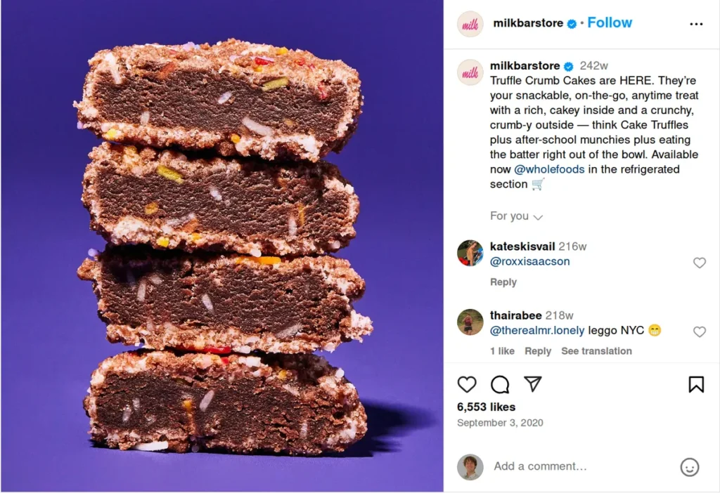 milkbar store instagram post featuring stack of chocolate truffle crumb cakes against purple background, descriptive caption calls them "snackable, on-the-go, anytime treat with a rich, cakey inside and crunchy, crumb-y outside," showing how detailed food descriptions make perfect instagram captions for product launches in the dessert space